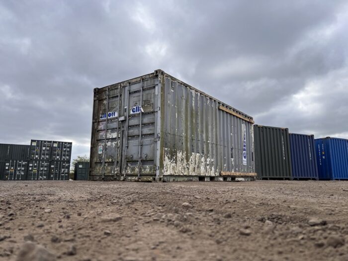 Front and side view of old 20ft shipping container with algae and flaking paint