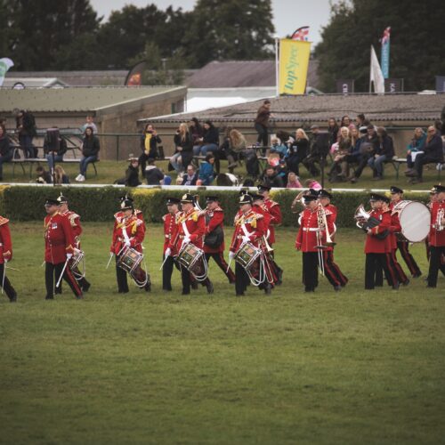 Marching band in red uniforms performing in the main ring.